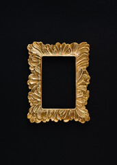 A creative arrangement made of a retro gold frame on a black background. Minimal flat lay concept...