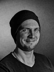 A smiling man on a black background with two light sources