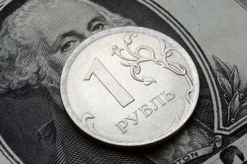 a coin with a face value of 1 ruble lies on a banknote of the American dollar. close-up
