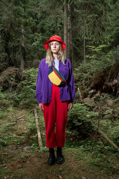 Woman wearing bucket hat standing in forest