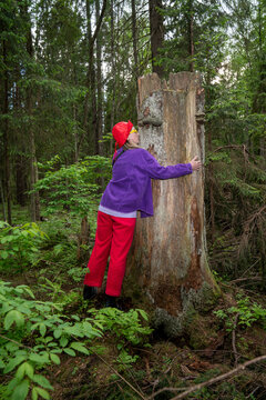 Woman kissing broken tree trunk