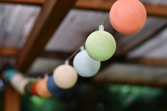 Colorful cotton light balls string hanging for decoration outdoors. Selective focus.