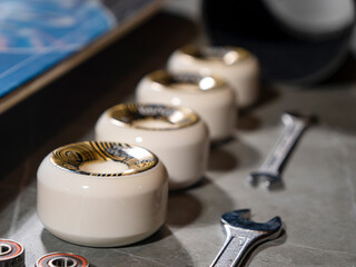 CLOSE UP: Overview of lined up skateboard wheels and wrenches on gray countertop - obrazy, fototapety, plakaty