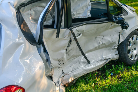 Car accident. White microcar heavily damaged on the side, with airbags exploded.