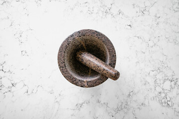 Mortar and pestle made from granite. Kitchen tool to be used to grind down spices. Top down shot