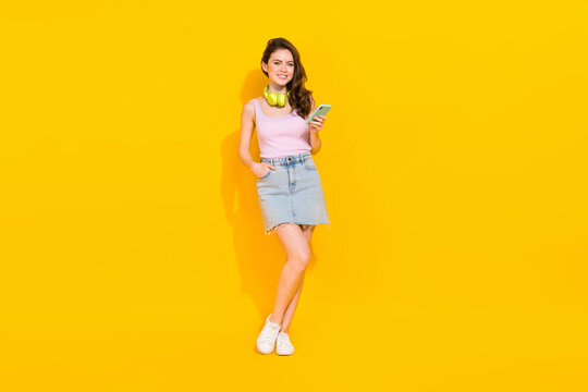 Full size portrait of cheerful gorgeous lady hold telephone good mood isolated on yellow color background