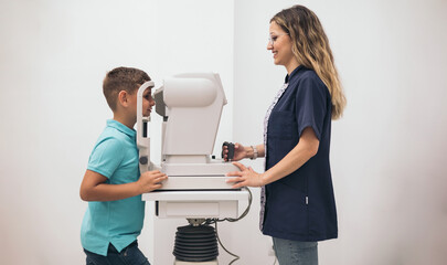 An optometrist woman taking the eye pressure of a child with a tomometer.