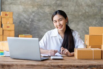 Young Asian business woman startup sme small business entrepreneur SME distribution warehouse with parcel mail box. SME Online marketing and product packaging and delivery service.