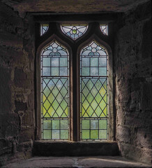 Fototapeta na wymiar Beautiful, intricate, ancient stained glass window in old stone building in Scotland