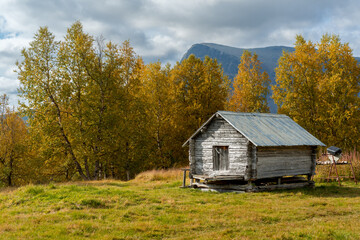 Old wooden cabin in arctic wilderness. Mountain cabin in Sarek National Park, Sweden. Sunny day of autumn in the arctic. Fall colors in Lapland.
