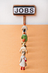 miniature figurines representing unempleyed people searching for jobs