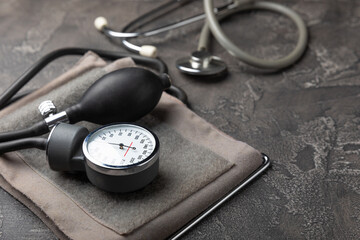 Gray tonometer on a black marble background. Medical equipment blood pressure monitor. Healthcare. Place for text. Medicine concept. The concept of cardiology.