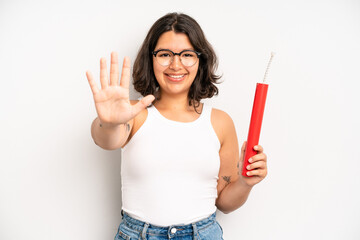 hispanic pretty girl smiling and looking friendly, showing number five. dynamite concept