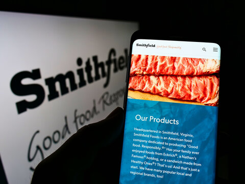 Stuttgart, Germany - 01-08-2022: Person holding smartphone with webpage of US food processing company Smithfield Foods Inc. on screen with logo. Focus on center of phone display.