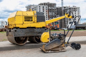 Vibratory rammer with vibrating plate on a construction site. Manual roller. Compaction of the soil before laying paving slabs. close-up.
