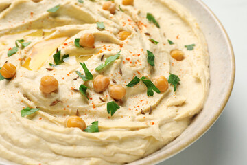 Tasty hummus with garnish in bowl, closeup