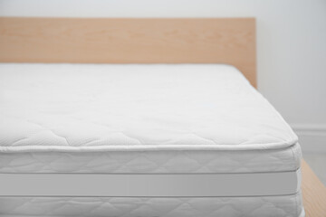 Comfortable bed with modern orthopedic mattress indoors, closeup. Space for text