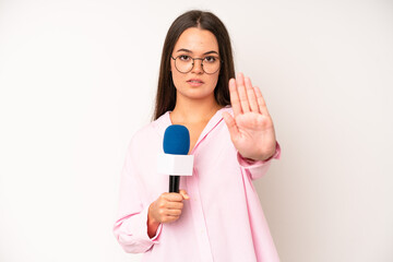 hispanic pretty woma looking astonished in disbelief. journalist with a microphone