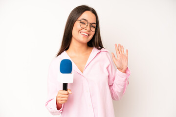 hispanic pretty woma looking happy and pleasantly surprised. journalist with a microphone