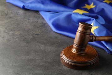 Wooden judge's gavel and flag of European Union on grey table. Space for text