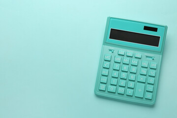 Turquoise calculator on light blue background, top view. Space for text