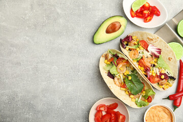 Delicious tacos with shrimps served on light grey table, flat lay. Space for text