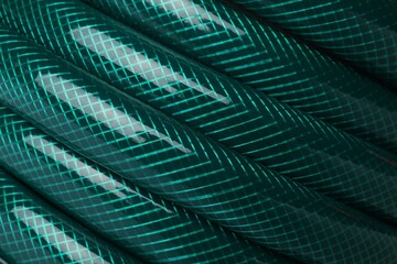 Green rubber watering hose as background, closeup