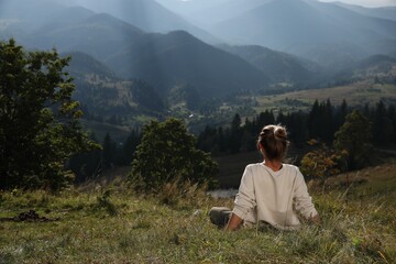 Fototapeta na wymiar Woman enjoying beautiful mountain landscape, back view. Space for text