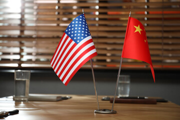 USA and China flags on wooden table in office. International relations