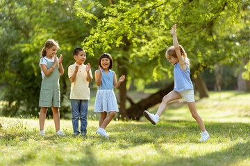 Obraz premium Group of asian and caucasian kids having fun in the park