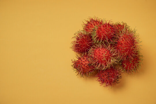 Lambutan on yellow background. Thai fruit in season with copy space.