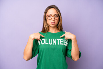 pretty caucasian woman feeling happy and pointing to self with an excited. volunteer concept