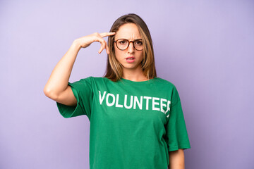 pretty caucasian woman feeling confused and puzzled, showing you are insane. volunteer concept