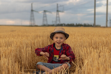 boy having fun in the field. a boy in a red shirt and shorts  shows thumbs down gesture and smiling