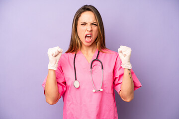 pretty caucasian woman shouting aggressively with an angry expression. medicine doctor concept