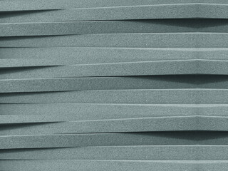 piles of gray foam sheet material of different thicknesses arranged crosswise.