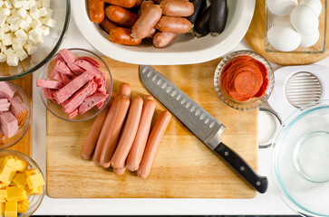 A variety of sausages on a wooden board. Cold cuts meat. Ingredients to make fiambre, Guatemala dish of all saints day.