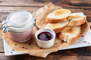French cuisine Foie gras toasts, goose liver pate berry marmalade. wooden background. Top view