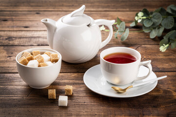 tea concept. white cup of tea and teapot, sugar in white bowl