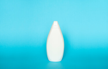 White plastic soap or shampoo bottle isolated on blue background. Skin care lotion. Bathing essential product. Shampoo bottle. Bath and body lotion. Fine liquid hand wash. Bathroom accessories.