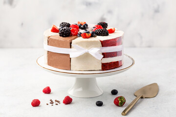 Selection of various cake pieces - cheesecake, chocolate cake, red velvet on cake stand on white stone background with berries. Overhead view, flat lay