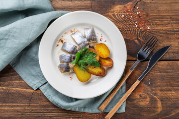 Food. Herring with onions and potatoes on a white plate. Top view. Free space for your text.