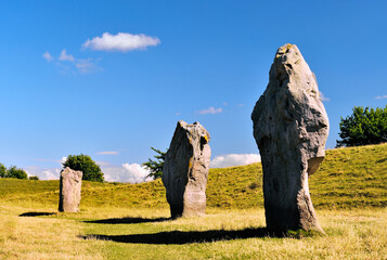Avebury Neolithic henge and stone circles, Wiltshire, England. Henge bank behind 3 megaliths of the...