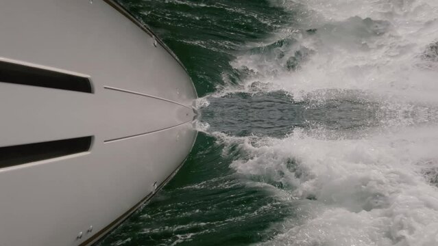 Sailboat sailing with huge waves breaking in slow-mo
