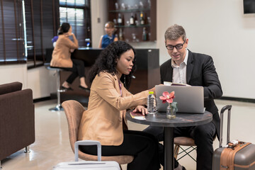 Caucasian Businessman and female businesswoman dealing business during waiting for boarding in airport VIP lounge, Airline business