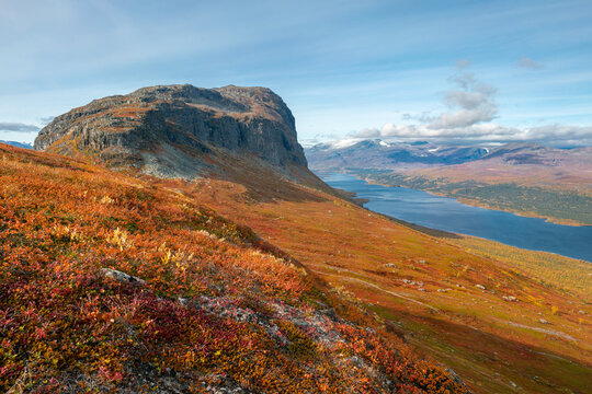 Massive of Lulep Gierkav mountain with Langas lake in the back in Lapland. Vivid autumn colors in arctic wilderness. Hiking above arctic circle. Stora Sjofallet, Stuor Muorkke national park, Sweden.