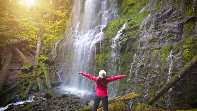 Woman hiker enjoying the view of the lush forest and moss at Proxy Falls in Oregon, USA.