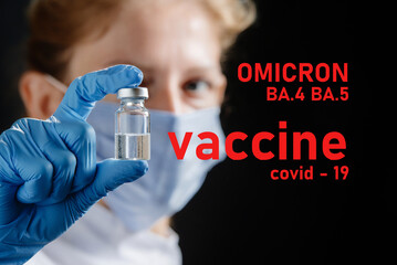 A female doctor wearing a protective mask holds a ba.5 and ba.4 omicron vaccine. Omicron BA.4 BA.5...