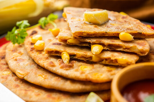 Sweet corn stuffed paratha or parotha served in a plate, Indian flatbread recipe made filling makai