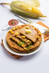 Sweet corn stuffed paratha or parotha served in a plate, Indian flatbread recipe made filling makai